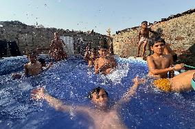 Boys Cool Off in A Pool During a Heatwave - Cairo