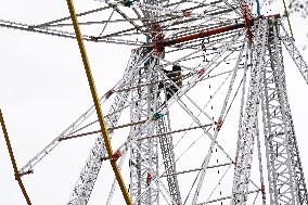A Labourer Works on A Giant Ferris Wheel - India