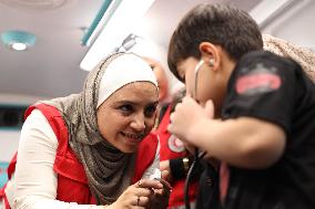 Syrian Red Crescent Volunteers Training Children In First Aid At Damascus International Fair