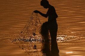 A Man Fishes in The Shallow Waters - India
