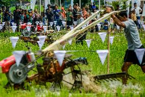 Farmers in a rice field tractors racing on a muddy rice field - Kebonagung
