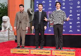 Jonas Brothers Hand And Footprint In Cement Ceremony - LA
