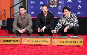 Jonas Brothers Hand And Footprint In Cement Ceremony - LA