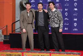 Jonas Brothers Hand And Footprint In Cement Ceremony - LA