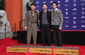 Jonas Brothers Hand And Footprint In Cement Ceremony - LA