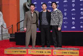 Jonas Brothers Hand And Footprint In Cement Ceremony - LA