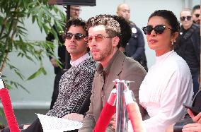 Jonas Brothers Hand And Footprint In Cement Ceremony - LA