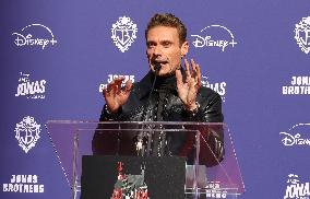 Jonas Brothers Hand And Footprint In Cement Ceremony - LA