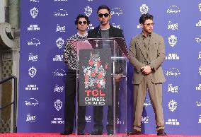 Jonas Brothers Hand And Footprint In Cement Ceremony - LA