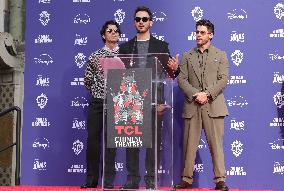 Jonas Brothers Hand And Footprint In Cement Ceremony - LA