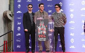 Jonas Brothers Hand And Footprint In Cement Ceremony - LA