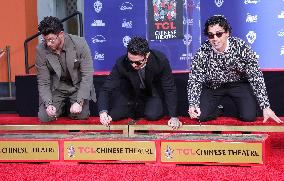 Jonas Brothers Hand And Footprint In Cement Ceremony - LA