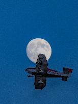 Flying Club Plane Passes Full Moon