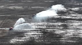 Farmers Irrigating Wheat in Fields