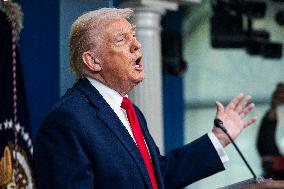 US President Trump speaks on to reporters ahead of trip to Davos