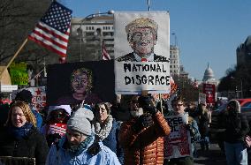 People protest on the first anniversary of President Donald Trump's second term in office