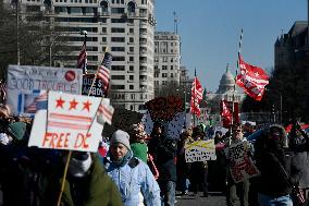 People protest on the first anniversary of President Donald Trump's second term in office