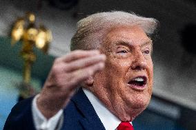 US President Trump speaks on to reporters ahead of trip to Davos