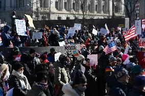 People protest on the first anniversary of President Donald Trump's second term in office